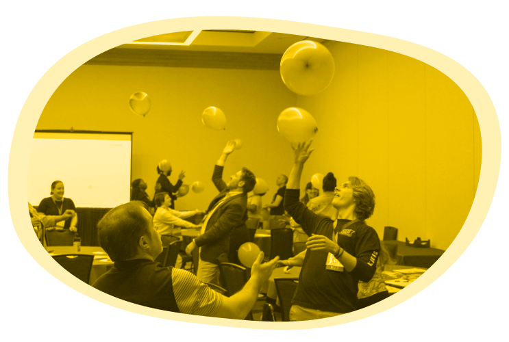 Educators play a team-building game; image is tinted yellow, one of Mizzen Education’s primary brand colors.